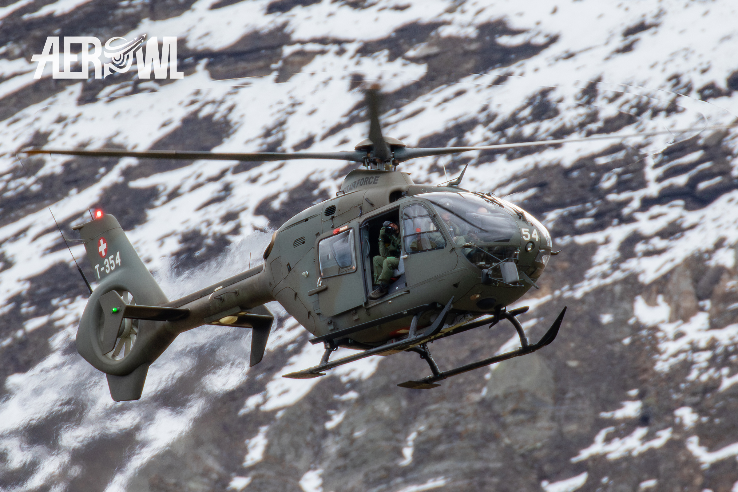 An Airbus H135M of the Swiss Airforce with an picture taking operator during the Axalp 2018 in the Swiss alps.