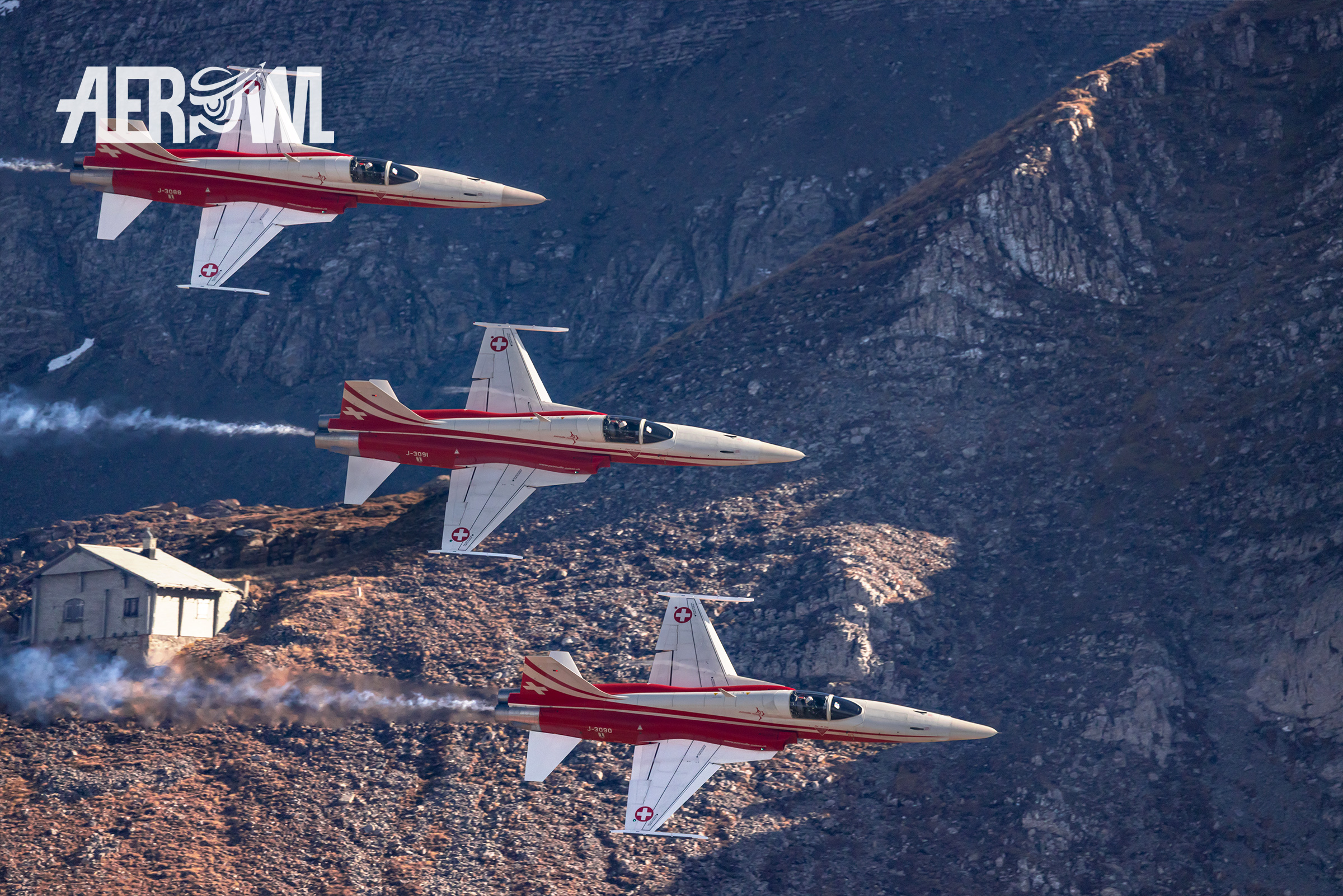 Three red and white Northrop F-5E Tiger II of the Patrouille Suisse fly by during the Axalp 2022 in Switzerland.