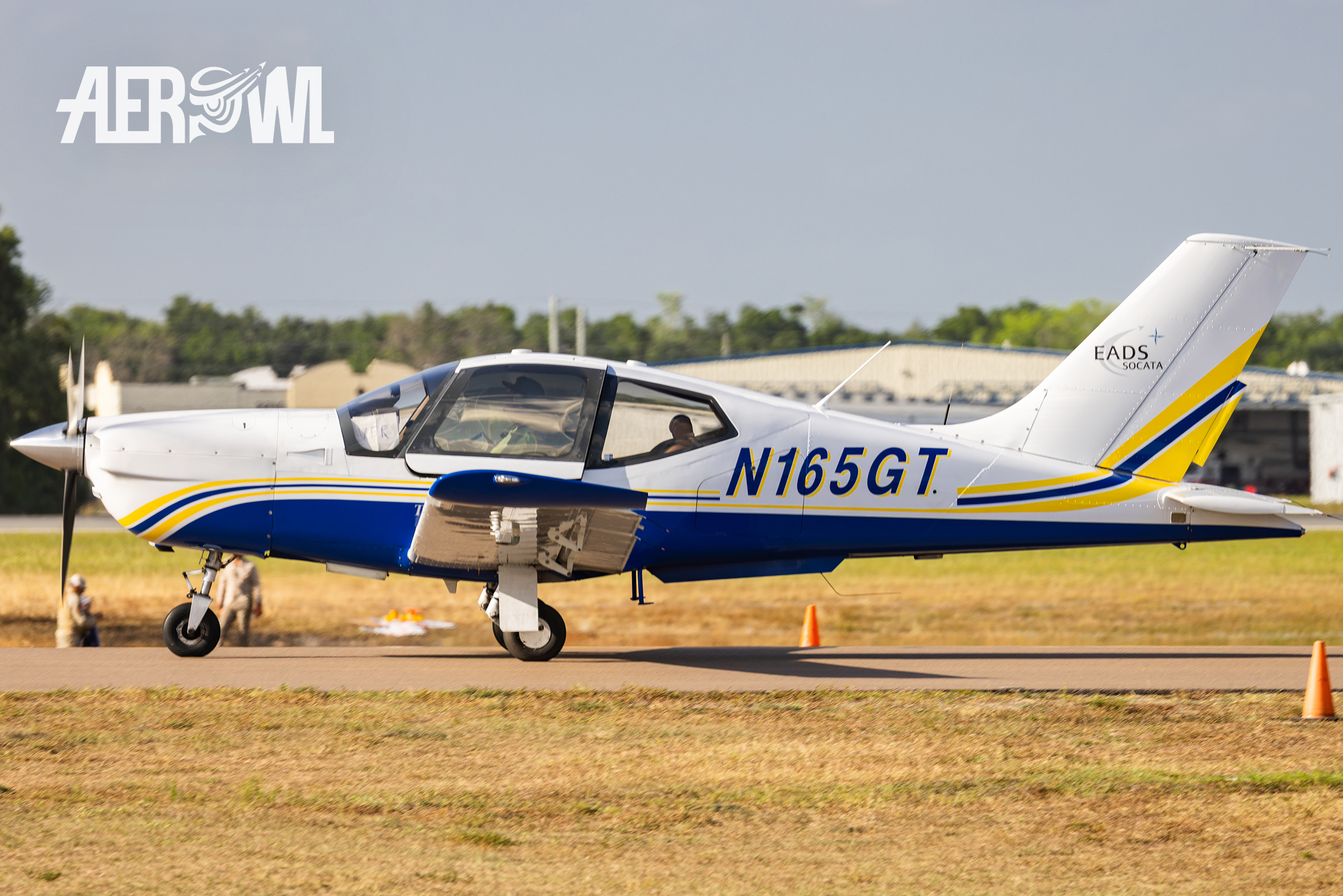 A white and blue colored Socata TB-20 Trinidad rolling towards the runway at Sun'n Fun 2025 in Lakeland, Florida.