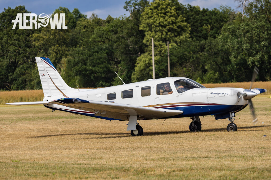 A Piper Saratoga II TC with a classic paint job taxis toward the Bienenfarm parking lot during the Stearman and Friends 2026 event in Brandenburg.
