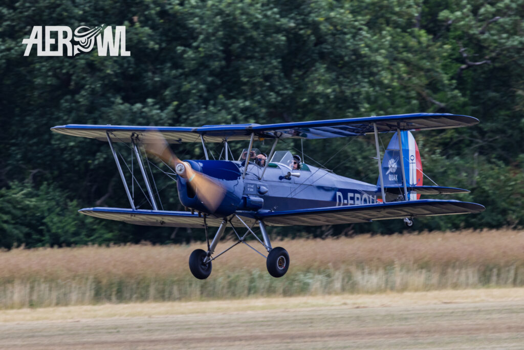 A blue Stampe and Vertongen SV-4C “D-EBOU” approaching the runway at the Bienenfarm in Brandenburg during the “Stearman & Friends 2026” event.